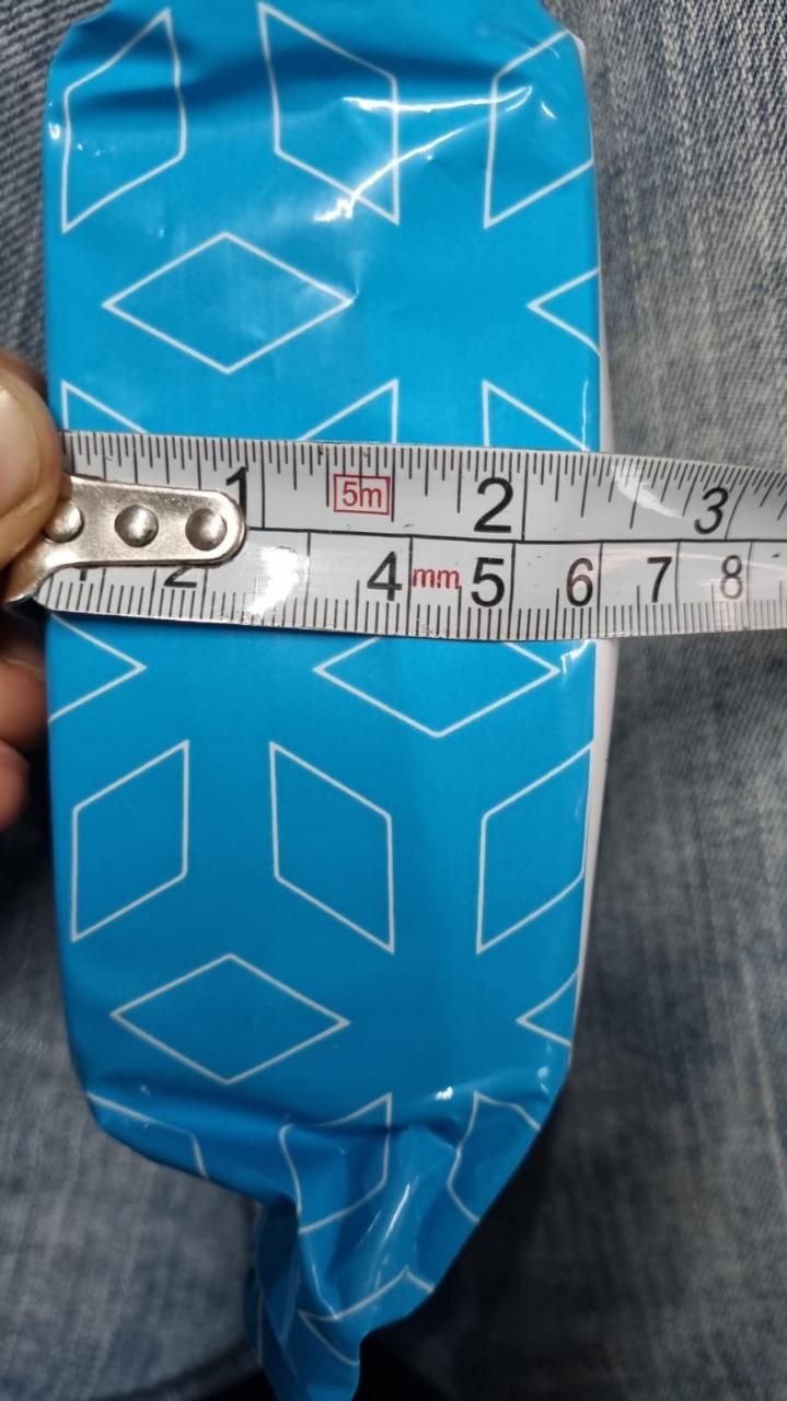 Blue pouch with geometric pattern being measured with a ruler