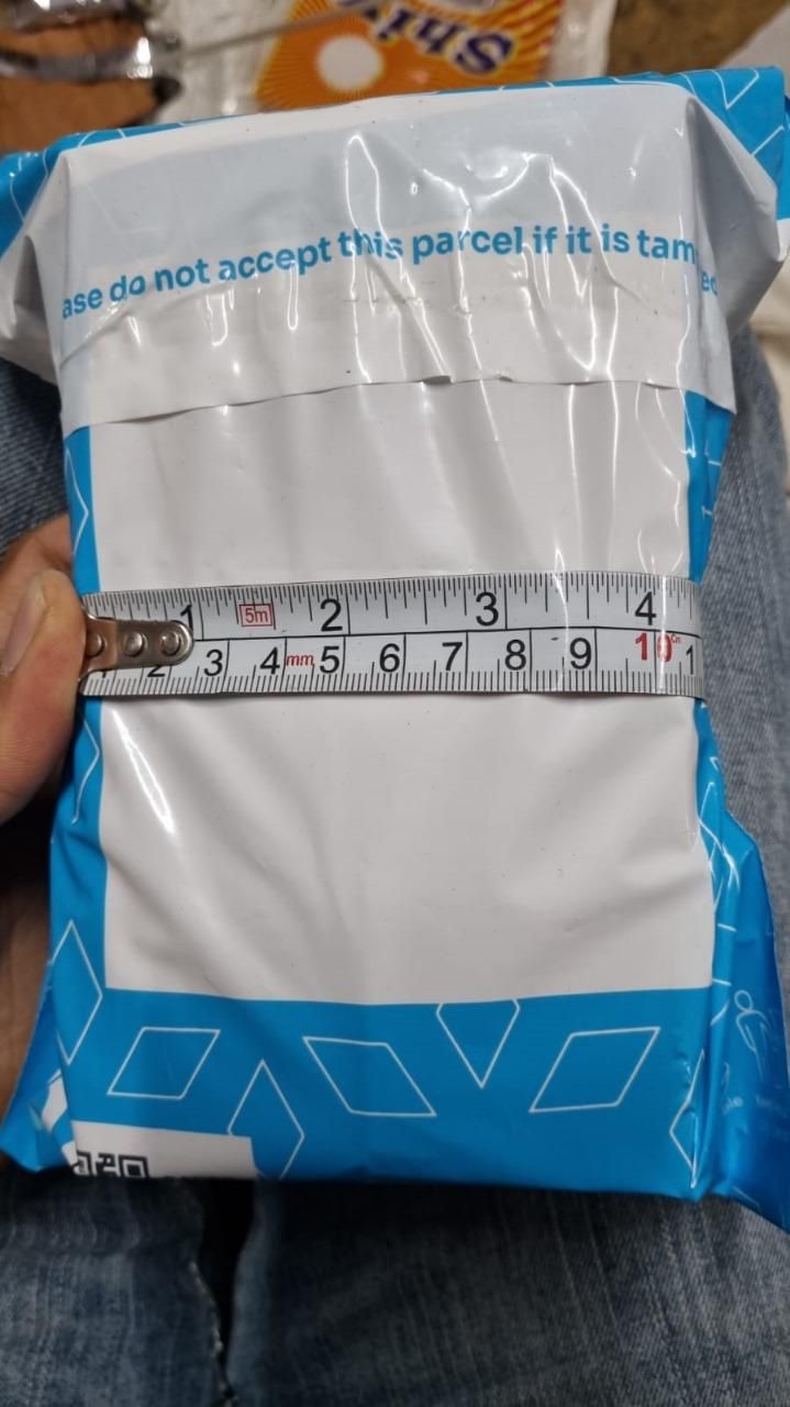 Package with a measuring tape on top, indicating measurement of dimensions.