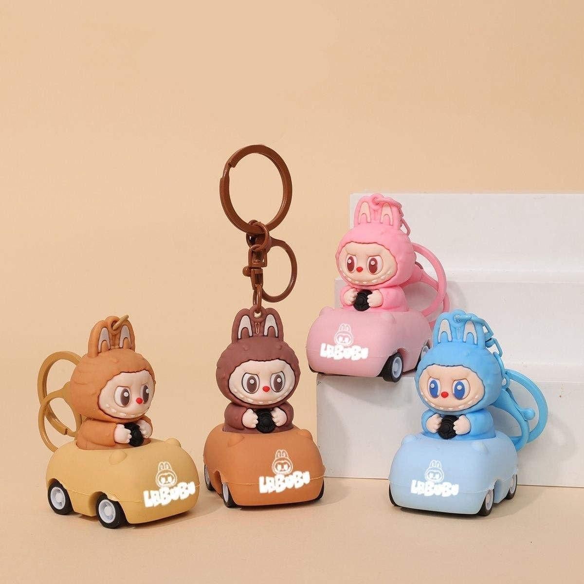 Four cartoon character keychains on small cars against a beige background