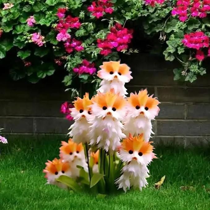 Decorative cat-shaped flowers in a garden setting with pink flowers and green grass.