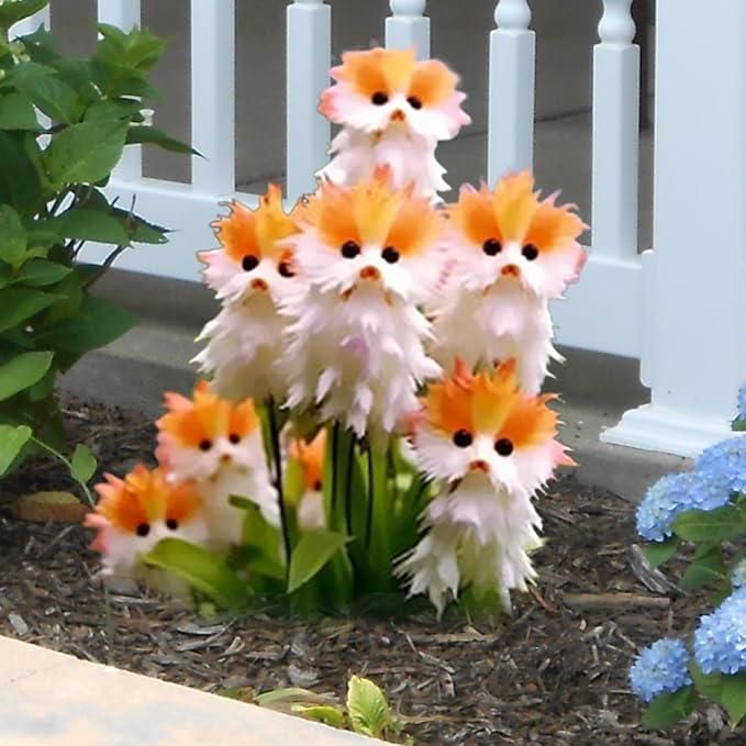Decorative garden stakes shaped like cartoonish cats with orange and white fur, standing in a garden setting.