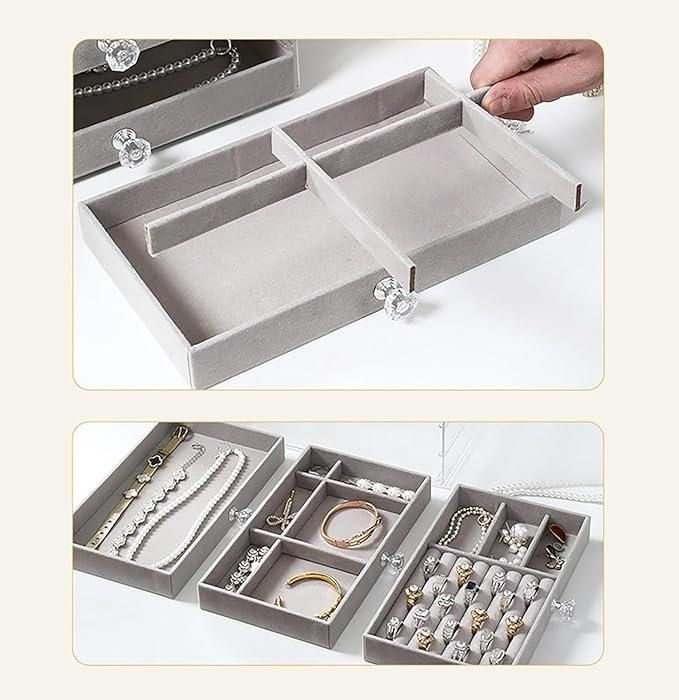 Gray jewelry organizer with compartments filled with various jewelry items on a white background.
