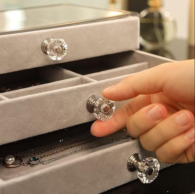 Hand opening a jewelry box with crystal knobs