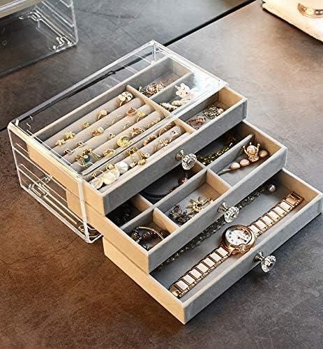 Jewelry organizer with compartments filled with earrings and a watch on a wooden surface.