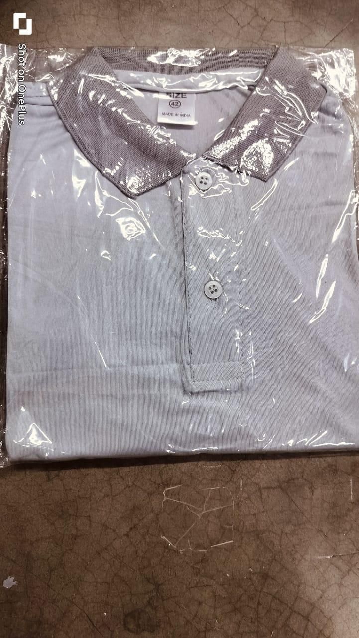 White polo shirt with gray collar in clear plastic packaging on a cardboard surface
