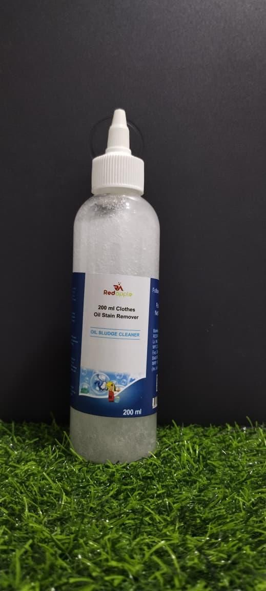 Bottle of oil stain remover on a grassy surface with a black background