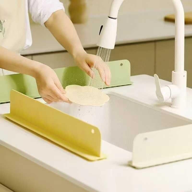 Person washing a dish in a kitchen sink with a yellow dish drying rack.