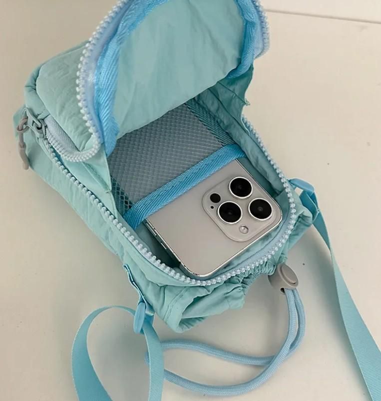 Light blue pouch with a phone inside on a light background