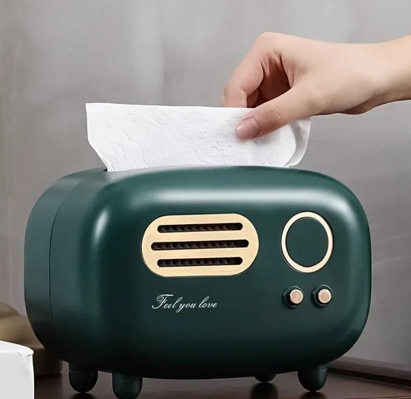 Green tissue box with radio design, featuring a hand taking a tissue.